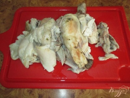 Сваренную курицу достать из кастрюли, охладить и отделить мясо от костей. Мясо порезать.