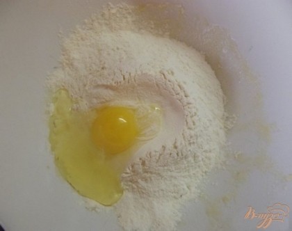 В миску с мукой вбейте яйцо. Хорошенько замесите их вместе. Всыпьте сахар и очень мягкое сливочное масло. Перемешайте.