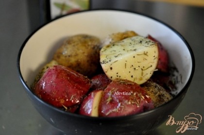 Картофель порезать на части, смешать с оливковым маслом ,розмарином и тимьяном.