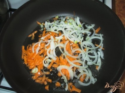 Нарезать лук и натереть морковь на терке. Положить в глубокую сковороду, добавить немного подсолнесного масла и пережарить.