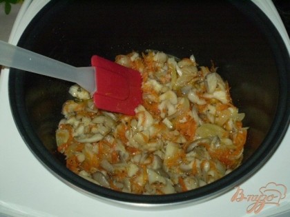 В кастрюле мультиварки на режиме "подогрев" жарим овощи: лук, морковь, грибы.