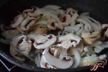 В сковорду где жарились бедрышки выложить луковицу и грибы, нарезанные тонко.Обжаривать в течении 5-8 мин.