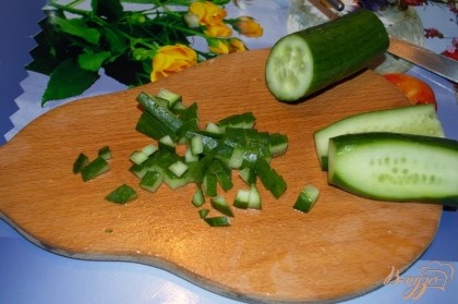 Свежий огурец, срезав попки, нарезать кубиком. Если готовите салат летом, то могут быть огурцы с жесткой кожицей. Ее лучше срезать.