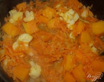 Добавьте к морковке с луком цветную капусту и тыкву, помешайте. Залейте примерно 100 мл хорошей воды, желательно кипяченой так, чтобы она покрыла овощи до половины. Добавьте чайную ложку сахара.