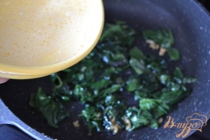 Яичную смесь вылить на шпинат. Сковороду накрыть крышкой и на медленном огне оставить 2-3 мин.