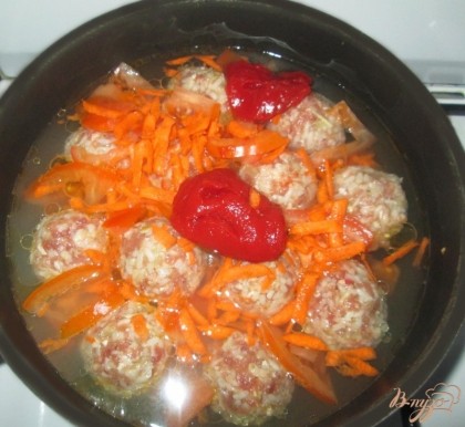 В глубокую сковороду положим шарики из фарша, добавим морковь, помидор, томатную пасту, лавровый лист, соль, перец и зелень по вкусу и зальем водой. Закроем крышкой и поставим на огонь.
