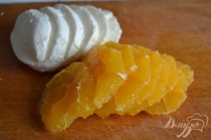 С апельсина срезать кожуру и нарезать на кружочки. Сыр нарезать .