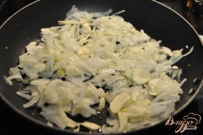 Разогреть духовку до 225 гр. На сковороде разогреть оливковое масло, обжарить лук и чеснок ,примерно 4 мин.