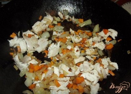 Куриную грудку отварите сначала до готовности. Сковородку, желательно чугунную, разогрейте и влейте на нее растительное масло. Когда масло нагреется, положите в сковородку репчатый лук и морковь. Огонь сделайте чуть меньше среднего и жарьте овощи до мягкости, постоянно перемешивая. Лук должен оставаться мягким, но подрумянится. После положите к овощам куриную грудку и обжарьте еще 2-3 минуты до румяного цвета.