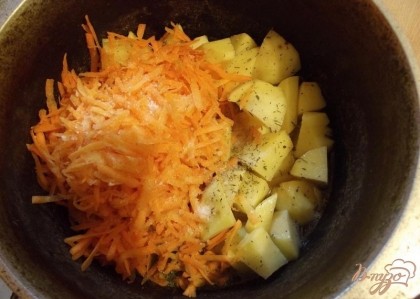 Следом через семь минут положите тертую морковь. Разровняйте ее сверху и не перемешивайте. Влейте еще 150 мл воды, накройте крышкой и тушите десять минут. Когда картофель станет мягким положите сверху всю паприку, красный молотый перец, тимьян и томатную пасту. Все перемешайте, попробуйте на соль и тушите до полной готовности картофеля. Картошка должна не просто стать мягкой, а и начать слегка разваливаться. Для этого по окончанию приготовления выключите газ и оставьте картофель под крышкой на 15 минут пропарится.