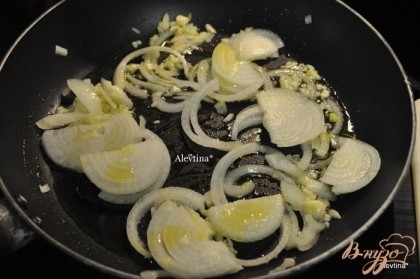На сковороду вылить масло, добавить лук и чеснок и обжаривать помешивая 3 мин.