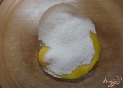 Отделите желтки от белков у яиц. Три желтка смешайте с сахаром в глубокой миске. Можно использовать коричневый (тростниковый) сахар для придания крему необычного вкусового оттенка.