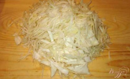 Нашинкуйте белокочанную капусту.  Это можно сделать обычным ножом или специальной шинковкой.Капусту посыпать щипкой соли и сахара. Перемешать капусту и помять руками. От этого капуста пустит сок.