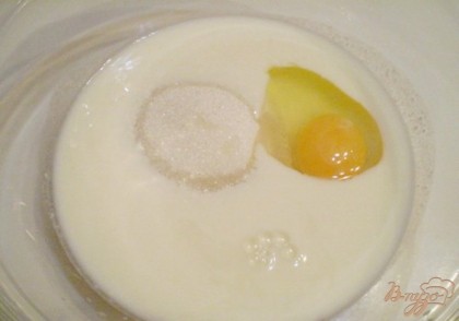 В глубокой мисочке смешиваем теплый кефир с сахаром и куриным яйцом. Перемешиваем. Нужно растворить сахар полностью.