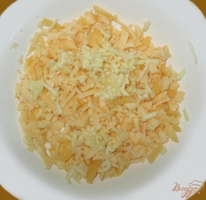 В тарелку с сыром добавляем, натертый на мелкой терке, чеснок.