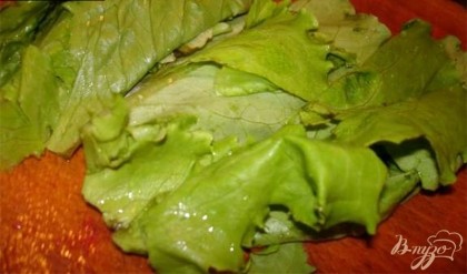  Нарвите руками и положите в салатник листья салата, предварительно вымыв и просушив их. Нарезать мелко любую зелень на ваш выбор.