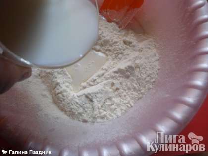 В чашку просеять 1 стакан муки, сделать углубление в центре, добавить щепотку соли, налить теплое молоко. И лопаточкой перемешать муку с молоком. Добавить растительное масло, перемешать.