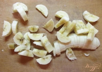 Начните приготовления с нарезки фруктов. Очистите банан и обязательно отрежьте у него кончики (носик и попку) с двух сторон. Нарежьте банан на дольки толщиной в 2-3 мм.