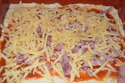 Натрите на терку твердый сыр. Выложите его поверх колбас. Посыпьте сверху специями и солью.  Разогрейте духовку до 200 градусов. Запекайте пиццу в духовке около 20 минут до готовности.