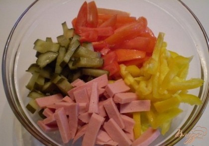 Соединяем в салатнике порезанные произвольно ингредиенты салата: молочную колбасу, свежие помидоры, маринованные огурцы, болгарский перец.