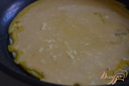 Когда белковый слой станет плотным вылить желтковую массу. Сковороду накрыть крышкой и оставить на 1-2 мин. пока желтовый слой не будет готов.