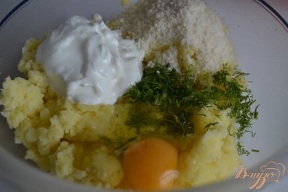 Пюре переложить в салатник, добавить пастообразный творог, выбить яйцо, зелень укропа и тертый пармезан.