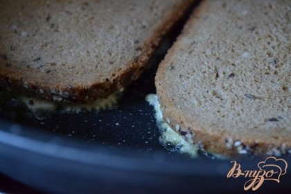 Сковороду (обязательно с антипригарным покрытием)  разогреть и чуть смазать оливковым маслом. Бутерброды уложить начинкой вниз и оставить на тихом огне на 2-3 мин.