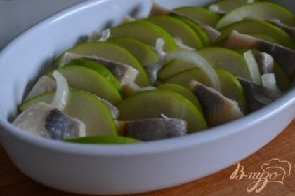 В тарелочку ( или любую посуду по вкусу) первым слоем выложить репчатый лук, затем ломтики яблока и кусочки сельди.