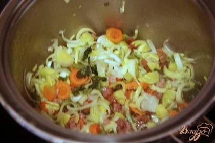 Добавить нарезанные овощи: морковь, лук, стебли сельдерея, тушить 5-8 мин. помешивая
