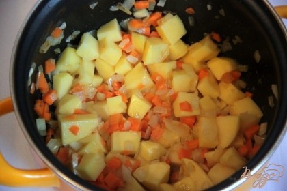 На сливочном масле в глубоком сотейнике обжарить до прозрачности лук (кубиками), добавить морковь (мелкими кубиками) и картофель (крупными кубиками), пожарить при помешивании 3-6 мин.