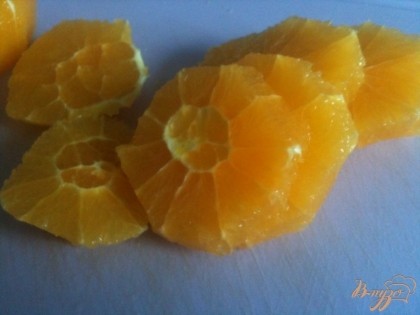 У апельсин срезать кожуру, нарезать на кусочки.