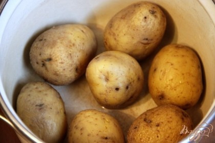 Отварить картофель в мундире в подсоленной воде