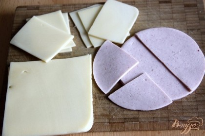 Нарезать на небольшие сегменты сыр и ветчину