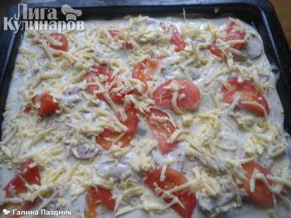 На тесто выложить помидоры и посыпать сверху пиццу тертым сыром. Помидоры немного посолить и поперчить.