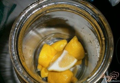 Лимон вымыть и разрезать на 8 частей, убрать косточки. Кусочки лимона положить в банку.