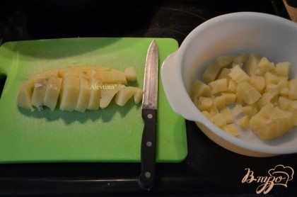 Положить картофель в кастрюлю и отварить. Дать постоять пока не будет достаточно холодным,чтобы его можно было взять в руки и порезать кубиками.