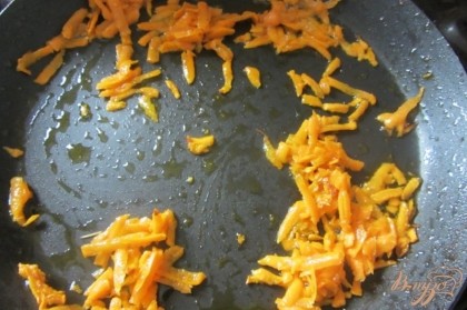 Морковку промыть под проточной водой, натереть на средней терке. Сковороду поставить на плиту разогреть, добавить подсолнечное масло. Обжариваем морковь на слабом огне.