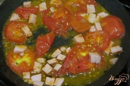 Вареную колбасу отчистить, нарезать кубиками. Обжарить на слабом огне вместе с помидорами по крышкой три минуты.