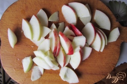 Сначала займемся яблоками. Яблоки необходимо хорошо вымыть под проточной водой и высушить салфеткой. После чего яблоки необходимо разделить на две половины и вытащить внутреннюю часть (косточки). Затем яблоки необходимо нарезать на тоненькие пластинки (так они лучше пропекутся).