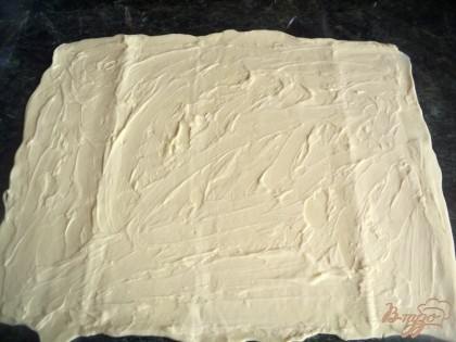 Слоеное тесто разморозить и раскатать в пласт толщиной 3-4 мм, смазать майонезом.