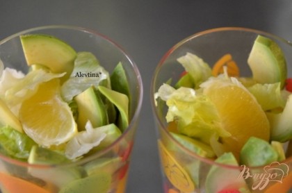 В тарелки или в стаканы нарвать салат.Затем выложить в салат авокадо и апельсин чередуя друг друга.