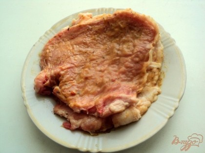 Стейки свинины хорошо отбить, слегка посолить и смазать со всех сторон маринадом для свинины. Накрыть пищевой пленкой и оставить мариноваться на 1 час.