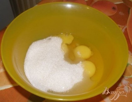 В миску разбила яйца и засыпала их сахаром.