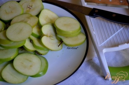 Разогреть духовку до 180 гр. Выстелить бумагу для выпечки на противень. Яблоки порезать слайсером тонко или ножом.