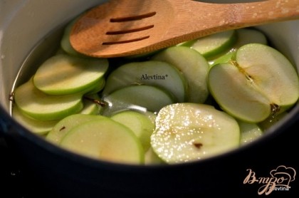 Выложить в емкость сахар и воду, перемешать и довести до кипения. Выложить яблоки порезанные, чтоб сироп полностью накрыл их. И варить 10-12 мин. Снять с огня.