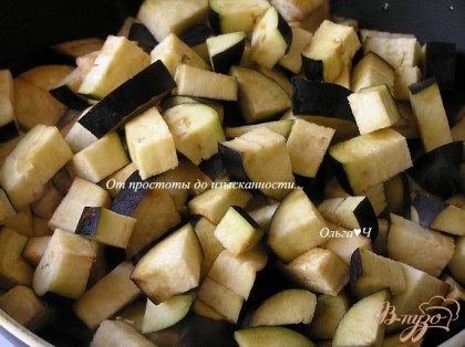 На растительном масле обжарить нарезанный лук до прозрачности, добавить нарезанные баклажаны, готовить 7-10 минут помешивая.