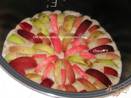 Тесто выложить в смазанную маслом чашу мультиварки. Сверху разложить яблоки, нарезанные дольками.
