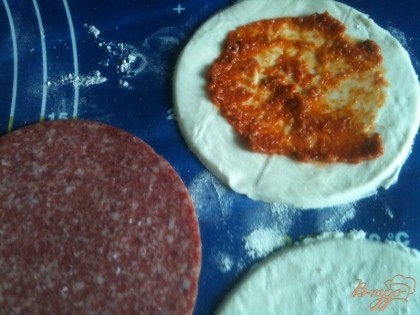 Из трех слоев теста и двух слоев салями сложить бутерброд, промазав по желанию внутри соусом.