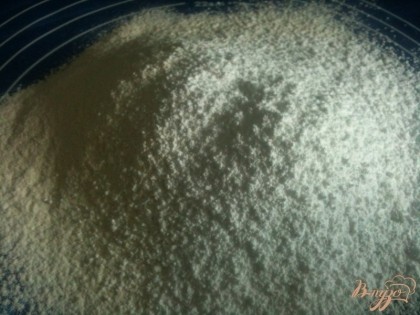 Муку просеять на рабочий стол, смешать с сахарной пудрой и щепоткой соли.