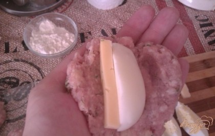 Берем мясную котлетку и делаем из нее плоскую лепешку, на которую кладем яичную дольку и кусочек сыра.